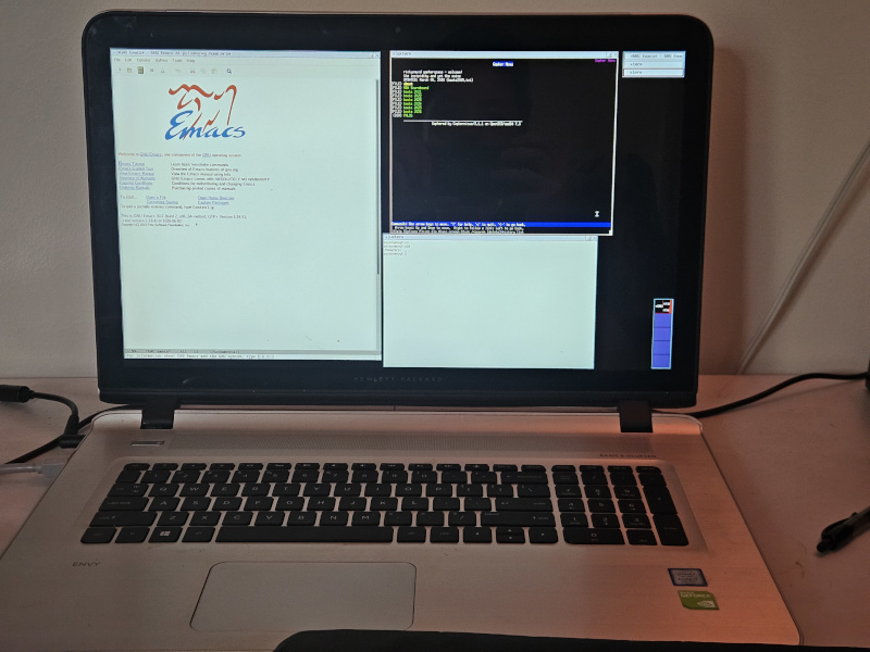 HP Envy laptop open with two uxterm windows and an emacs window